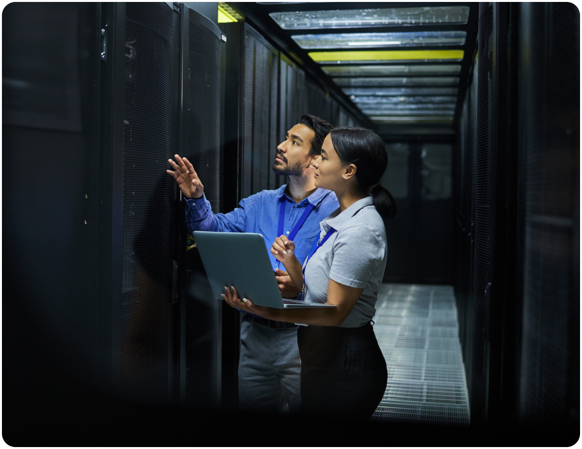 Two IT professionals reviewing server racks in a data center.